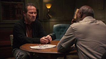 Movie still from “The Sunset Limited” (2011), directed by Tommy Lee Jones – Two men are sitting at a table talking to each other; Medium shot, Over the shoulder angle