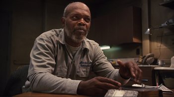 Movie still from “The Sunset Limited” (2011), directed by Tommy Lee Jones – An older man sitting at a table looking at the camera; Close Up shot, Low angle