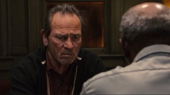 Movie still from “The Sunset Limited” (2011), directed by Tommy Lee Jones – An older man sitting in front of another older man; Close Up shot, Over the shoulder angle