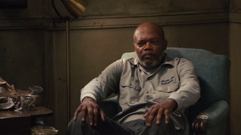 Movie still from “The Sunset Limited” (2011), directed by Tommy Lee Jones – An older man sitting in a chair in a room; Medium shot, High angle