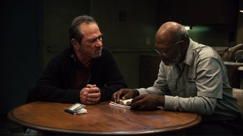 Movie still from “The Sunset Limited” (2011), directed by Tommy Lee Jones – Two men sitting at a table looking at a book; Medium shot, Over the shoulder angle