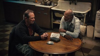 Movie still from “The Sunset Limited” (2011), directed by Tommy Lee Jones – Two men are sitting at a table in a kitchen; Medium shot, High angle