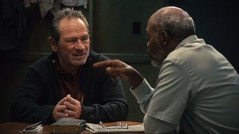 Movie still from “The Sunset Limited” (2011), directed by Tommy Lee Jones – Two older men sitting at a table talking to each other; Medium shot, Over the shoulder angle