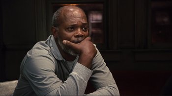 Movie still from “The Sunset Limited” (2011), directed by Tommy Lee Jones – An older man sitting in front of a window with his chin resting on his hand; Close Up shot, High angle