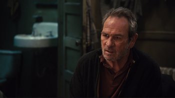 Movie still from “The Sunset Limited” (2011), directed by Tommy Lee Jones – An older man with gray hair is looking at the camera; Close Up shot, Over the shoulder angle