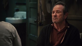 Movie still from “The Sunset Limited” (2011), directed by Tommy Lee Jones – An older man sitting in front of a bathroom sink; Close Up shot, Over the shoulder angle