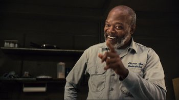 Movie still from “The Sunset Limited” (2011), directed by Tommy Lee Jones – An older man is smiling while holding his hand out; Close Up shot, Low angle