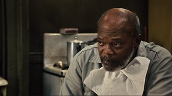 Movie still from “The Sunset Limited” (2011), directed by Tommy Lee Jones – An older man sitting in front of an oven; Close Up shot, Over the shoulder angle