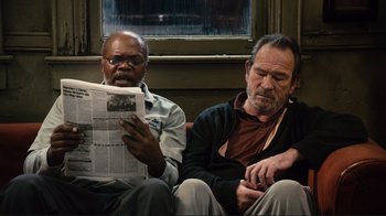 Movie still from “The Sunset Limited” (2011), directed by Tommy Lee Jones – Two men are sitting on a bench and one is reading a newspaper; Medium shot, Low angle