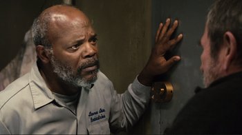 Movie still from “The Sunset Limited” (2011), directed by Tommy Lee Jones – An older man leaning against a wall with his hand on a door knob; Close Up shot, Low angle