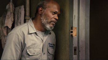 Movie still from “The Sunset Limited” (2011), directed by Tommy Lee Jones – An older man standing in front of a door; Close Up shot, Over the shoulder angle