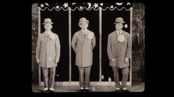 Movie still from “The Sunshine Boys” (1975), directed by Herbert Ross – A group of men standing next to each other wearing hats; Wide shot, Low angle