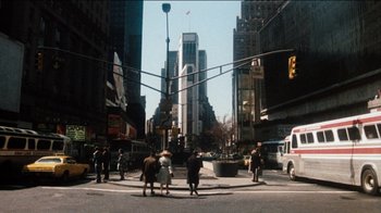 Movie still from “The Sunshine Boys” (1975), directed by Herbert Ross – A group of people standing on the side of a road; Extreme Wide shot, High angle