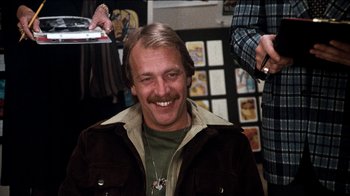 Movie still from “The Sunshine Boys” (1975), directed by Herbert Ross – A man smiles while getting his hair combed; Close Up shot, Over the shoulder angle