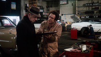 Movie still from “The Sunshine Boys” (1975), directed by Herbert Ross – A man in a hat and a man in a brown jacket; Medium shot, Over the shoulder angle