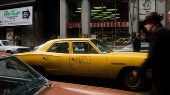 Movie still from “The Sunshine Boys” (1975), directed by Herbert Ross – A yellow taxi cab driving down the street; Wide shot, Low angle