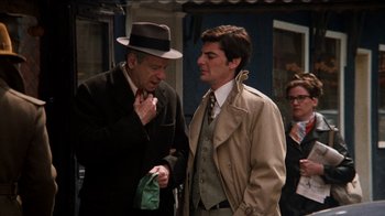 Movie still from “The Sunshine Boys” (1975), directed by Herbert Ross – A man in a hat and a man in a trench coat; Medium shot, Over the shoulder angle