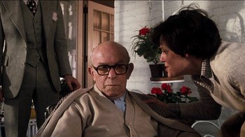 Movie still from “The Sunshine Boys” (1975), directed by Herbert Ross – An older man sitting on a chair next to an older woman; Medium shot, Over the shoulder angle