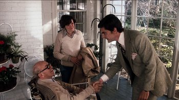 Movie still from “The Sunshine Boys” (1975), directed by Herbert Ross – A man shaking hands with another man on a porch; Medium shot, Over the shoulder angle