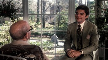 Movie still from “The Sunshine Boys” (1975), directed by Herbert Ross – A man wearing a suit and tie sitting next to a window; Medium shot, Over the shoulder angle