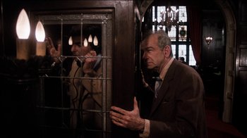 Movie still from “The Sunshine Boys” (1975), directed by Herbert Ross – A man standing next to another man behind bars; Medium shot, Over the shoulder angle