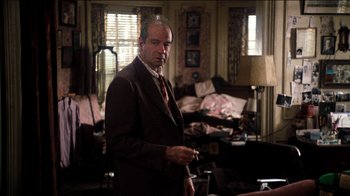 Movie still from “The Sunshine Boys” (1975), directed by Herbert Ross – A man in a suit and tie standing in a living room; Medium shot, Over the shoulder angle