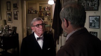 Movie still from “The Sunshine Boys” (1975), directed by Herbert Ross – A man wearing a suit and bow tie talking to another man in a suit; Medium shot, Over the shoulder angle