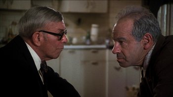 Movie still from “The Sunshine Boys” (1975), directed by Herbert Ross – Two older men are facing each other in a kitchen; Close Up shot, Over the shoulder angle