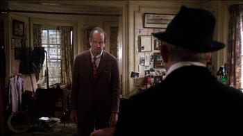 Movie still from “The Sunshine Boys” (1975), directed by Herbert Ross – A man in a suit and tie standing next to another man in a suit and tie; Medium shot, Over the shoulder angle