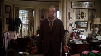 Movie still from “The Sunshine Boys” (1975), directed by Herbert Ross – A man in a suit and tie in a room; Medium shot, Low angle