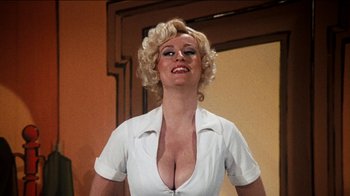 Movie still from “The Sunshine Boys” (1975), directed by Herbert Ross – A woman in a white shirt is posing for a picture; Close Up shot, Low angle
