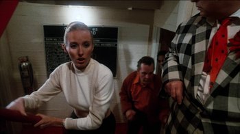 Movie still from “The Sunshine Boys” (1975), directed by Herbert Ross – A man and a woman are standing in front of a wall; Medium shot, Low angle
