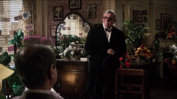 Movie still from “The Sunshine Boys” (1975), directed by Herbert Ross – An older man wearing a suit and bow tie in front of a mirror; Medium shot, Over the shoulder angle
