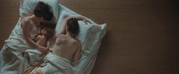Movie still from “The Sweet Hereafter” (1997), directed by Atom Egoyan – A man laying in a bed with his head on a pillow; Medium shot, Overhead angle