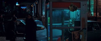 Movie still from “The Sweet Hereafter” (1997), directed by Atom Egoyan – Two people are looking out of a window at a bus stop at night; Medium shot, Over the shoulder angle