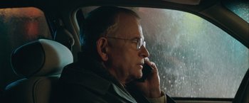 Movie still from “The Sweet Hereafter” (1997), directed by Atom Egoyan – An older man sitting in a car talking on a cell phone; Close Up shot, Over the shoulder angle