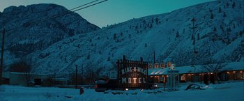 Movie still from “The Sweet Hereafter” (1997), directed by Atom Egoyan – A motel sign is lit up at night in the snow; Extreme Wide shot, High angle