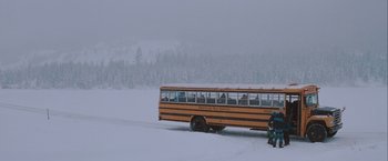Movie still from “The Sweet Hereafter” (1997), directed by Atom Egoyan – A school bus driving down a snow covered road; Extreme Wide shot, High angle