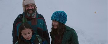 Movie still from “The Sweet Hereafter” (1997), directed by Atom Egoyan – A woman wearing a blue hat standing next to a man wearing a green jacket; Medium shot, Over the shoulder angle