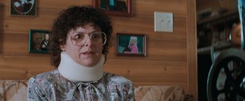 Movie still from “The Sweet Hereafter” (1997), directed by Atom Egoyan – A woman wearing a neck brace in front of a picture; Close Up shot, Over the shoulder angle