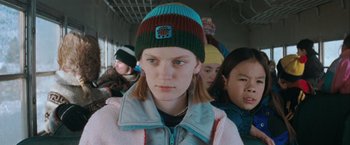 Movie still from “The Sweet Hereafter” (1997), directed by Atom Egoyan – A woman with a hat on a crowded train; Close Up shot, Over the shoulder angle