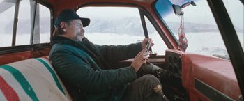 Movie still from “The Sweet Hereafter” (1997), directed by Atom Egoyan – A man sitting in the driver's seat of a car; Medium shot, High angle