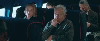 Movie still from “The Sweet Hereafter” (1997), directed by Atom Egoyan – An older man sitting on a train with a woman; Medium shot, Over the shoulder angle