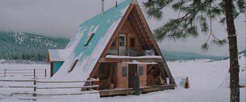 Movie still from “The Sweet Hereafter” (1997), directed by Atom Egoyan – An a - frame cabin in the middle of a snowy field; Extreme Wide shot, Low angle