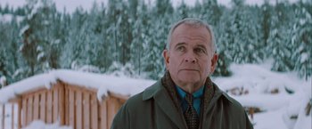 Movie still from “The Sweet Hereafter” (1997), directed by Atom Egoyan – An older man wearing a jacket and tie in the snow; Close Up shot, Over the shoulder angle