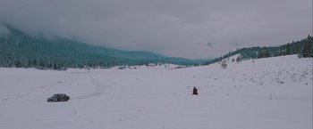 Movie still from “The Sweet Hereafter” (1997), directed by Atom Egoyan – A person sitting in the middle of a snow covered field; Extreme Wide shot, High angle