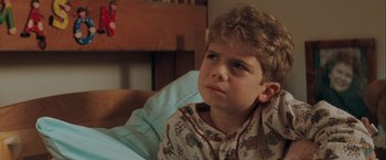 Movie still from “The Sweet Hereafter” (1997), directed by Atom Egoyan – A young boy sitting in a bed looking sad; Close Up shot, High angle
