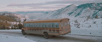 Movie still from “The Sweet Hereafter” (1997), directed by Atom Egoyan – An old school bus driving down a snow covered road; Extreme Wide shot, High angle