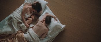 Movie still from “The Sweet Hereafter” (1997), directed by Atom Egoyan – A couple of people laying in a bed; Medium shot, Overhead angle
