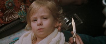 Movie still from “The Sweet Hereafter” (1997), directed by Atom Egoyan – A little girl getting her hair cut by a barber; Close Up shot, Over the shoulder angle
